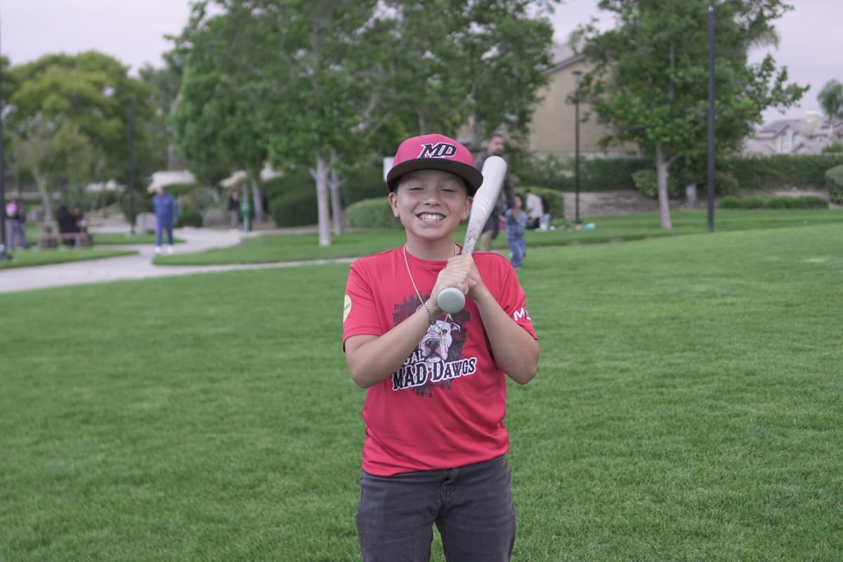 MAD Dawgs player smiling with bat