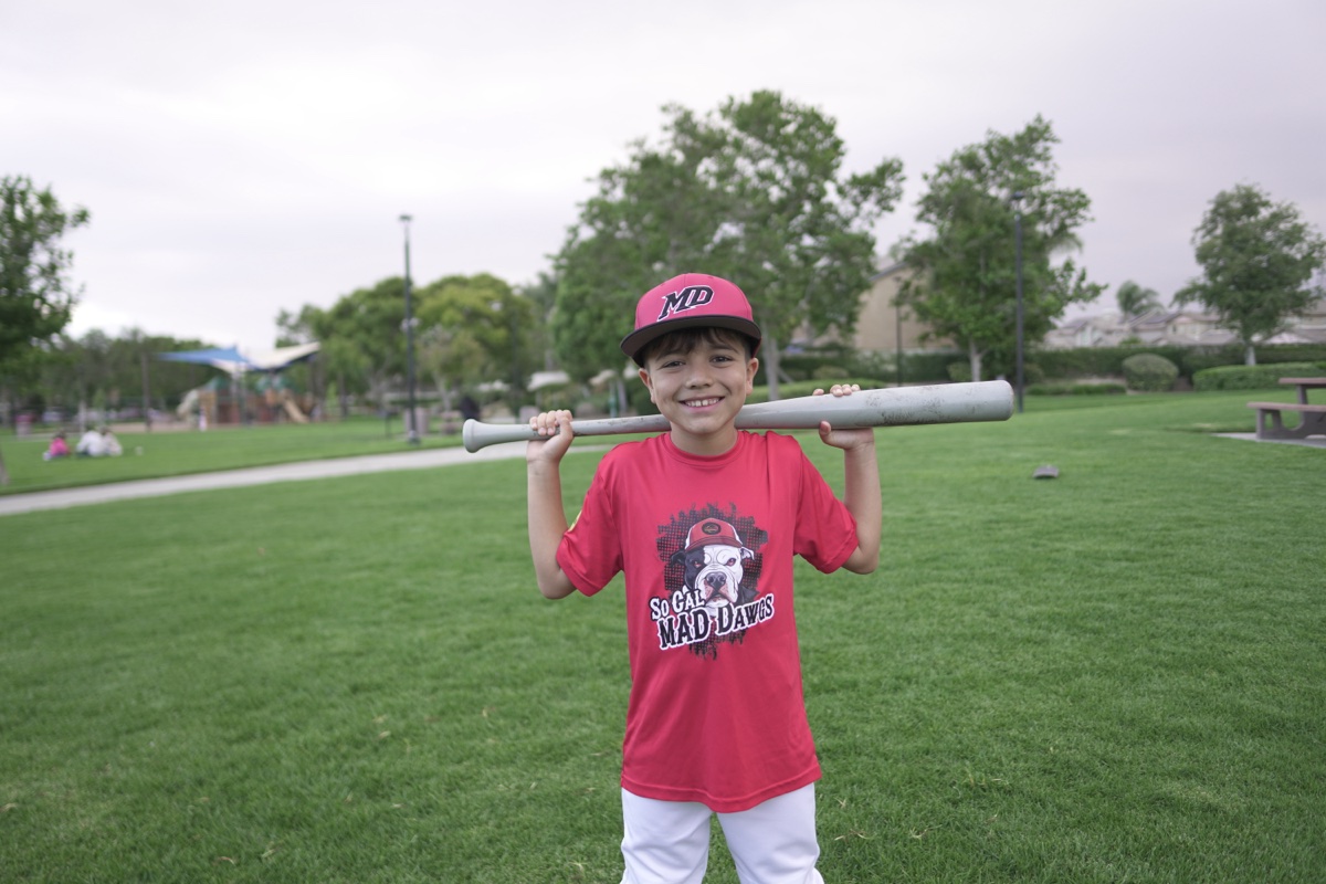 MAD Dawgs player posing with bat across shoulders