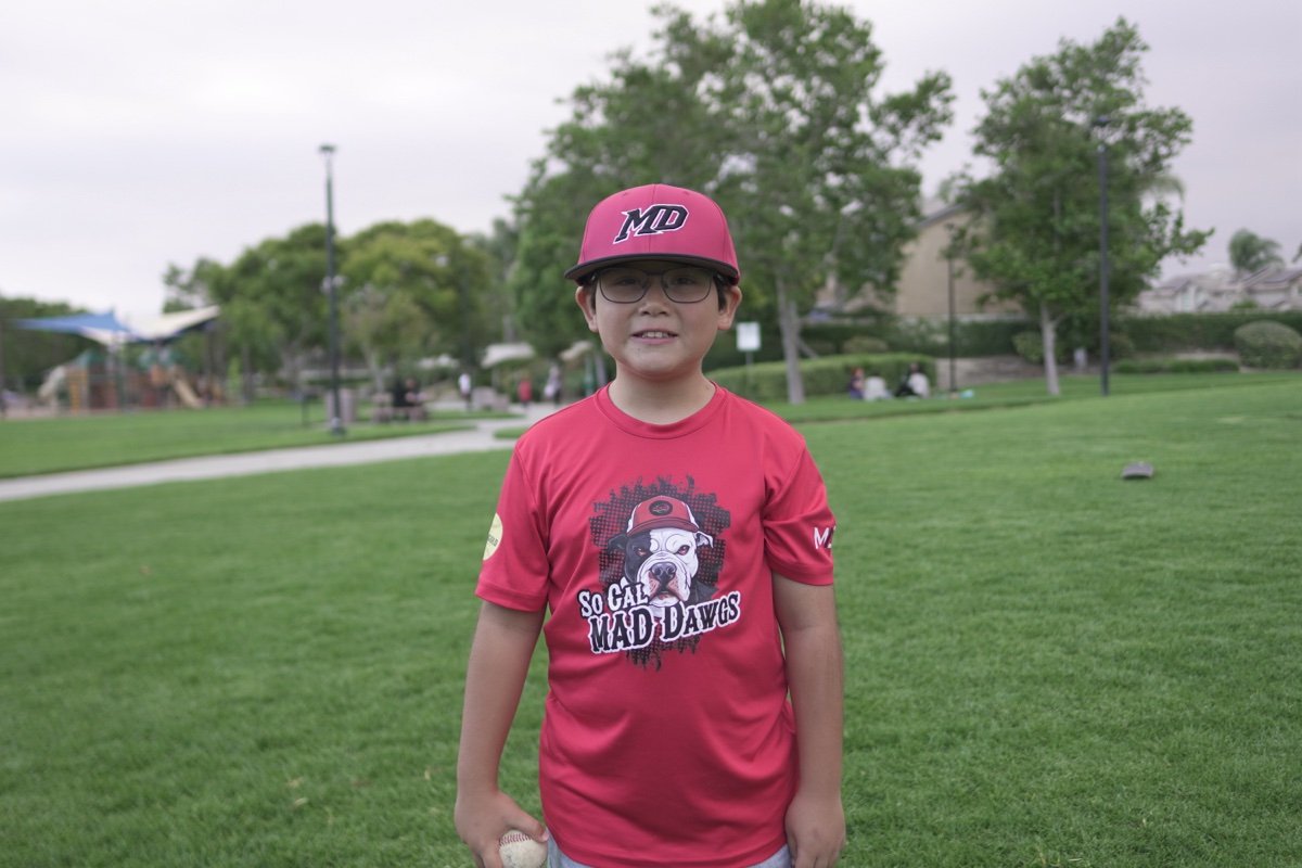 MAD Dawgs player with glasses holding baseball